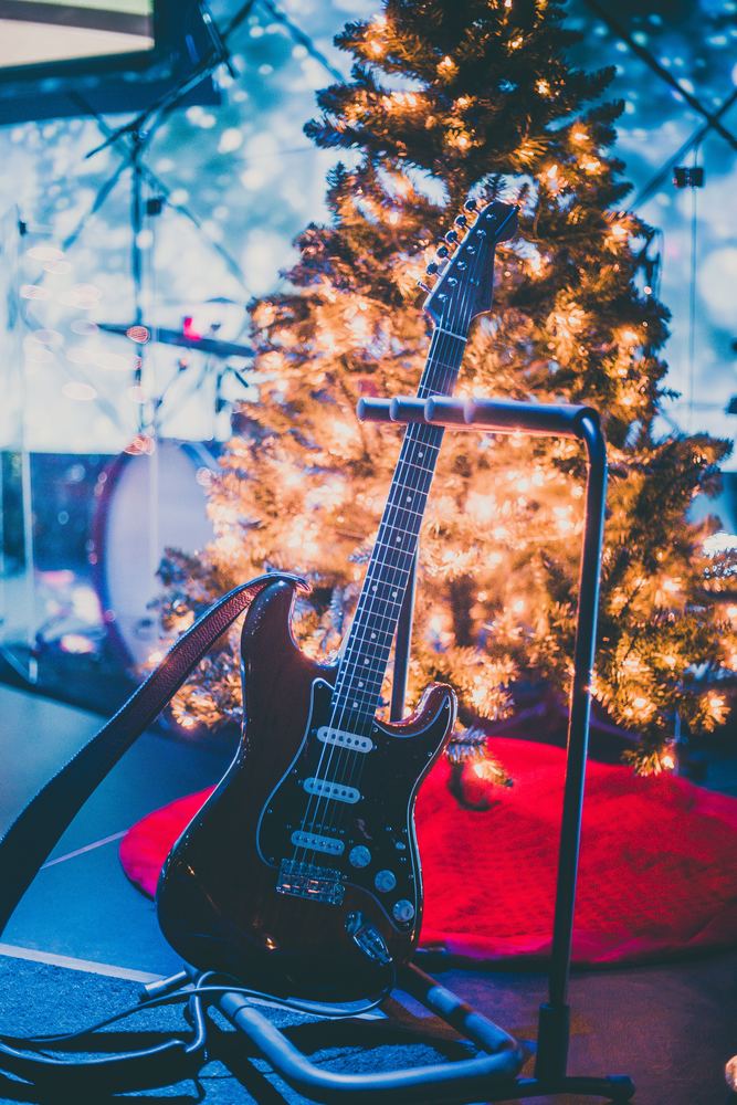Elektrisk gitar på scenen foran et juletre